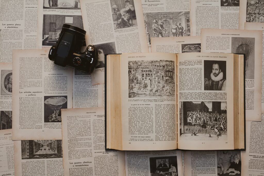 Camera and book surrounded by newspaper clippings.